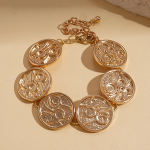 Close-up of golden geometric textured round links on bracelet with lobster clasp detail