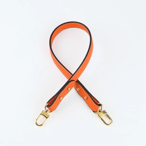 Close-up of orange lychee grain leather shoulder strap with gold metal swivel snap hooks