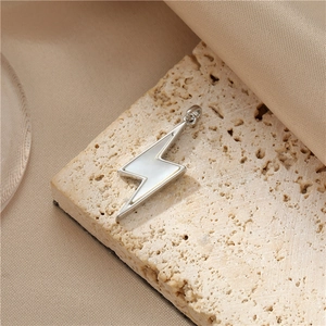 Macro detail of lightning bolt pendant with silver metal and white shell inlay