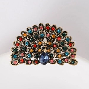 Detailed view of peacock brooch with multicolored crystals and a teardrop gemstone