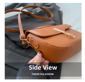Detail view of caramel brown saddle bag showing matte texture and gold metal buckle
