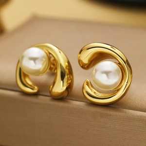 Detail of 18k gold-plated curved stud earrings featuring smooth white pearls
