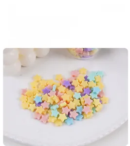 Vue détaillée de breloques étoiles en PVC colorées pour DIY sur un plateau en relief