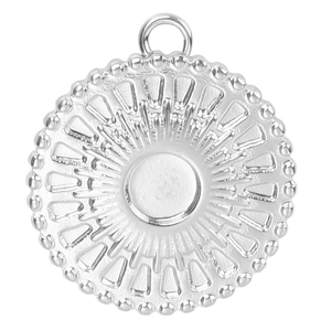 Macro view of silver stainless steel round pendant with sun pattern and textured border