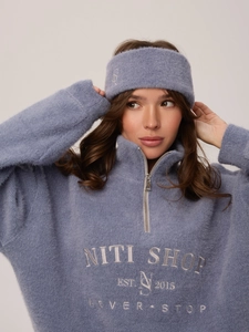 Primo piano della maglia in maglia blu Morandi con mezza zip e ricamo del marchio NITI