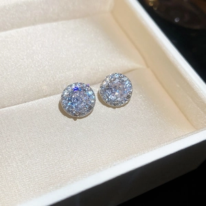 Macro shot of silver stud earrings with a central cubic zirconia and a sparkling halo