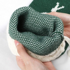 Knitted Christmas stocking with green and white snowflake patterns showing high-quality texture