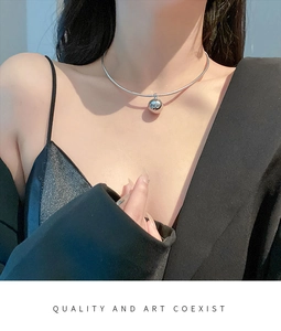 Detail of silver spherical pendant necklace shown on neck with Quality and Art Coexist text