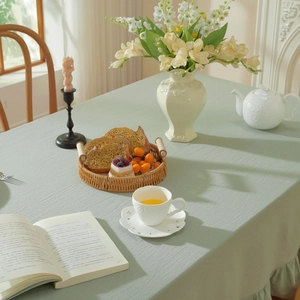 Detail view of light green linen tablecloth with elegant ruffled lotus leaf edges