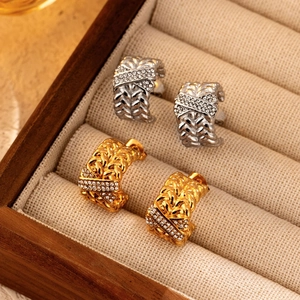 18K gold and silver stainless steel C-shape earrings with diamonds on a wooden box