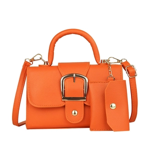 Orange candy-colored crossbody bag with gold buckle and matching mini pendant