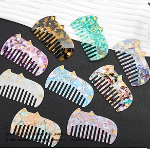 Close-up of nine colorful cat-shaped acetate hair combs with leopard and marble patterns