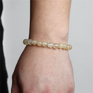 Detail of 8mm natural yellow crystal bead bracelet worn on wrist showing stone texture