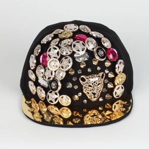 Close-up of golden leopard head and metallic studs on black hip-hop baseball cap