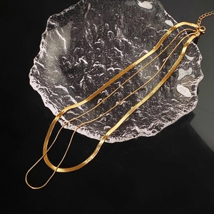 Three-layer gold snake chain necklace in titanium steel on glass tray display