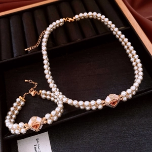 Detail of vintage gold-plated pearl necklace and bracelet set in a black velvet jewelry box