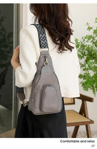 Graue Vintage Brusttasche mit gemustertem breitem Gurt an einem Model in stilvoller Umgebung