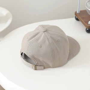 Detail view of khaki cotton baseball cap featuring an adjustable metal buckle strap back