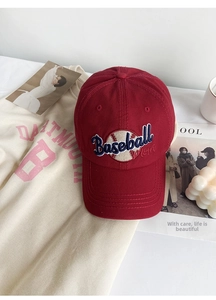 Detail shot of a dark red Baseball Mom cap with white 3D embroidery on a lifestyle background