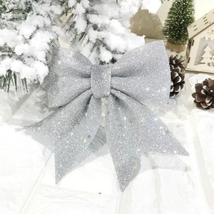Sparkling silver Christmas bow decoration with glitter on a snowy winter background