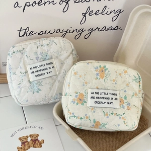 Close-up of floral quilted cosmetic pouches featuring elegant floral patterns and cotton fabric