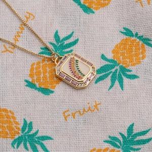 Close-up of gold rectangular rainbow pendant with colorful zircon and purple stones