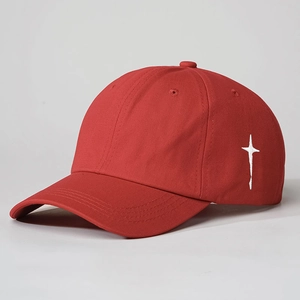 Red cotton baseball cap featuring white side cross embroidery and detailed brim stitching