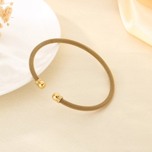 Close-up of 18K gold-plated stainless steel mesh woven cable bracelet with ball ends