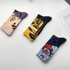 Detailed flat lay of three cotton socks with colorful artistic graffiti and nature patterns
