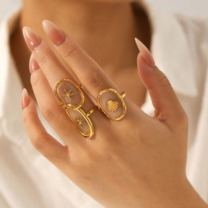 Gold stainless steel starfish and shell rings with transparent resin on female hand