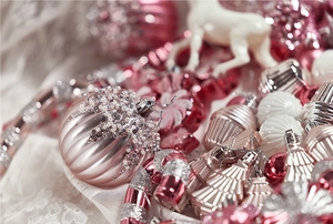 Close-up of pink and silver Christmas ornaments with glitter details and festive textures