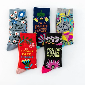 Detail view of 5 pairs of cotton socks with colorful floral patterns and humorous text