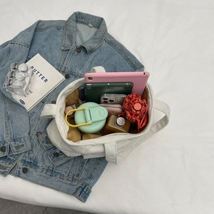 White corduroy tote bag showing large capacity with tablet and daily essentials