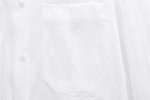 Detailed macro view of white woven shirt pocket stitching and transparent buttons