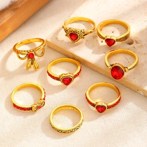 8-piece vintage gold ring set featuring red gemstones and bow designs in warm lighting