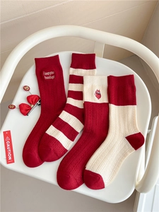 Detail of four pairs of red and white cashmere socks with festive holiday embroidery