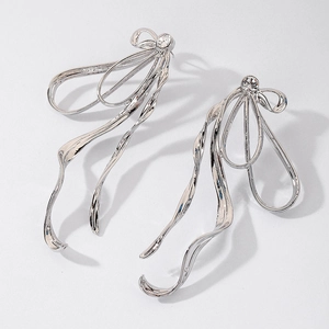 Close-up of silver ribbon earrings with sparkling zircon stones in a sleek metallic design
