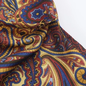 Close-up of premium paisley print silk fabric with vibrant patterns and elegant drape