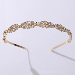 Close-up of golden crown headband with leaf-shaped sparkling rhinestones on white background