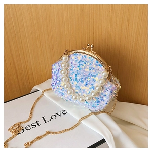 Detail of sequined shell bag with iridescent white sequins and luxury pearl handle