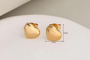 Detailed close-up of gold heart-shaped stud earrings measuring 8.2mm with mirror finish
