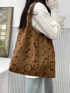 Detail of a brown tote bag featuring elegant rose jacquard texture for casual shoulder use