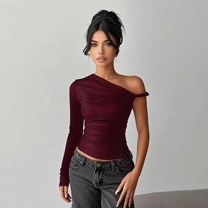 Detail of burgundy one-shoulder top with side ruching and asymmetrical sleeve design