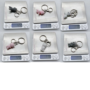 Detail showing various flocked cat keychains on electronic scales for weight measurement