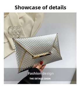 Detail of silver textured envelope clutch featuring a gold metallic clasp and trim