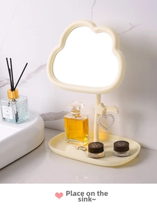 Cloud-shaped vanity mirror with star hook and jewelry tray on a bathroom counter