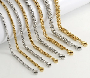 Macro detail of 18K gold and silver keel chains with secure lobster clasps on white background