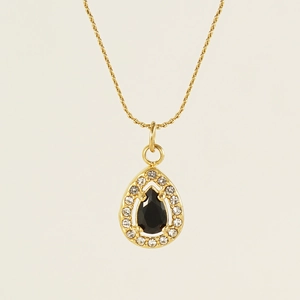 Macro detail of gold 18K teardrop pendant with black gemstone and zircon halo