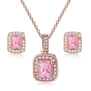 Macro detail of rose gold jewelry set with emerald-cut pink zircon and diamond halo