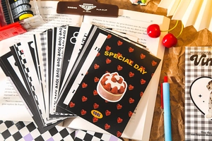 Detail of vintage postcards with retro heart and cake patterns in warm aesthetic lighting
